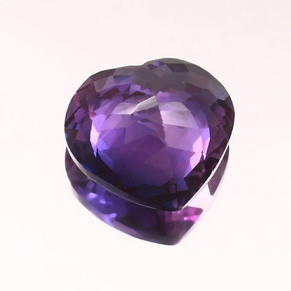 Heart-shaped Purple-Pink Sapphire gemstone on a white background
