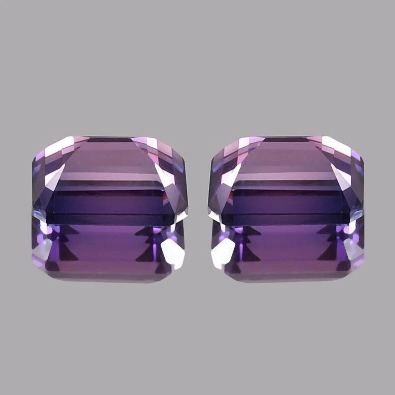 Pair Ceylon Purple Sapphire purple gemstones on a gray background