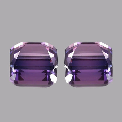 Pair Ceylon Purple Sapphire purple gemstones on a gray background
