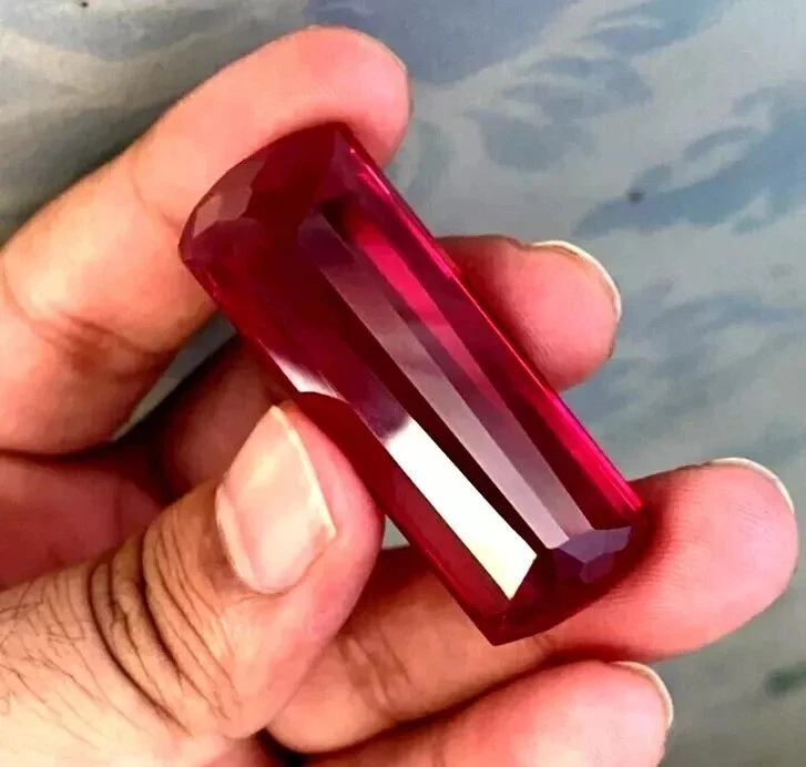 Red huge burma Ruby held in a hand with a blurred background