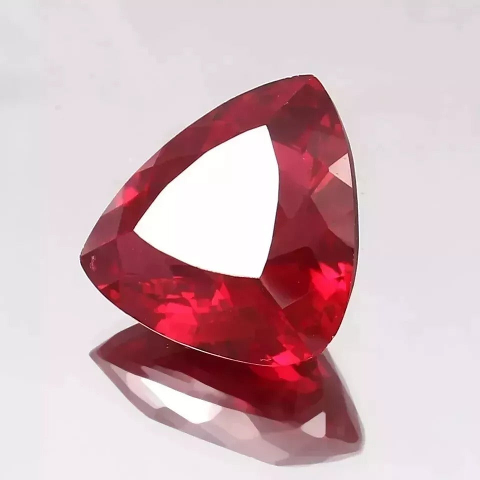 Faceted Mozambique Blood Red Ruby Trillion Cut gemstone on a white background