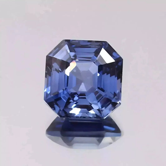 Royal Blue Sapphire gemstone with a clear cut on a light gray background