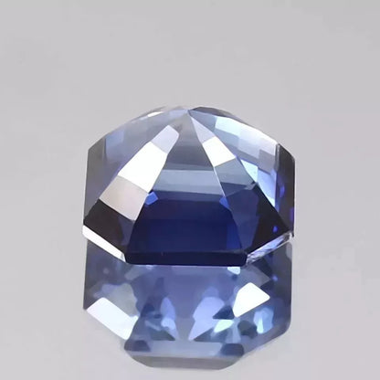 Faceted Royal Blue Sapphire  gemstone on a gray background