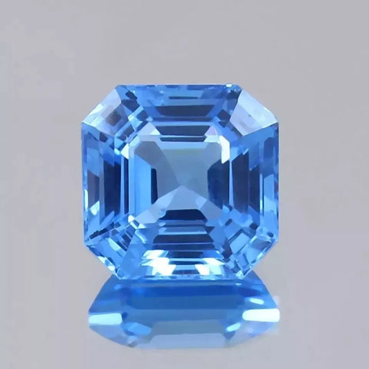 Faceted Ceylon Blue Spinel gemstone on a gray background