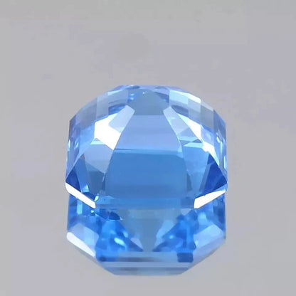 Faceted Ceylon Blue Spinel gemstone on a gray background