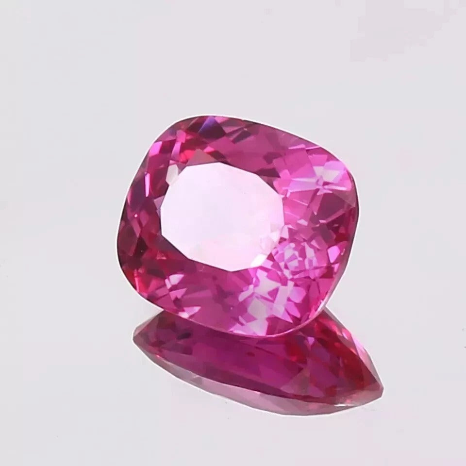 Pink sapphire gemstone on a light gray background