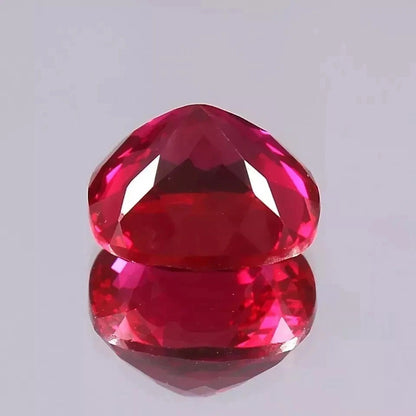Faceted red Mozambique Ruby gemstone on a light gray background