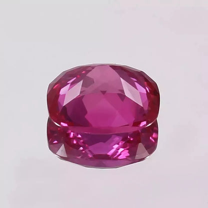 Faceted Pink sapphire gemstone on a light gray background