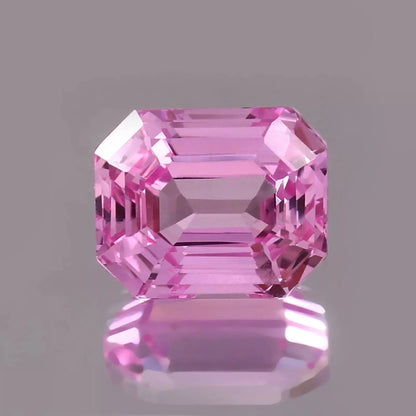 Pink Padparadscha Sapphire gemstone on a gray background