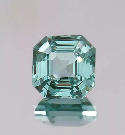 Green Paraiba Tourmaline gemstone on a light gray background
