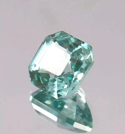 Green Paraiba Tourmaline gemstone on a light gray background