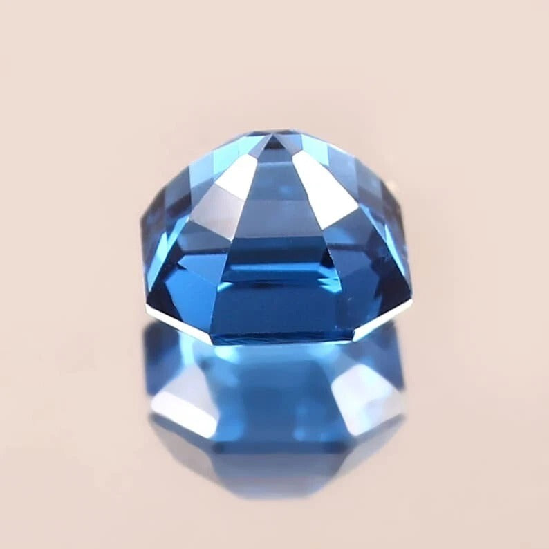 Faceted blue  Indicolite Tourmaline gemstone on a beige background