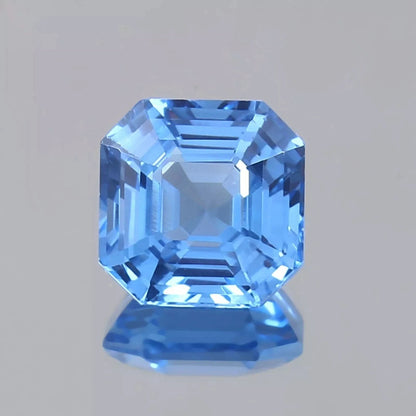 Faceted Ceylon Blue Sapphire gemstone on a gray background