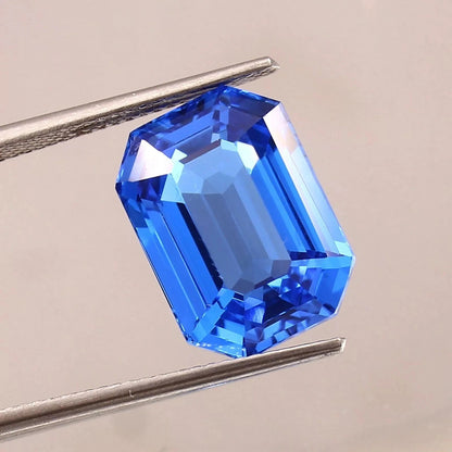 Blue sapphire sri lanka gemstone held by tweezers on a neutral background