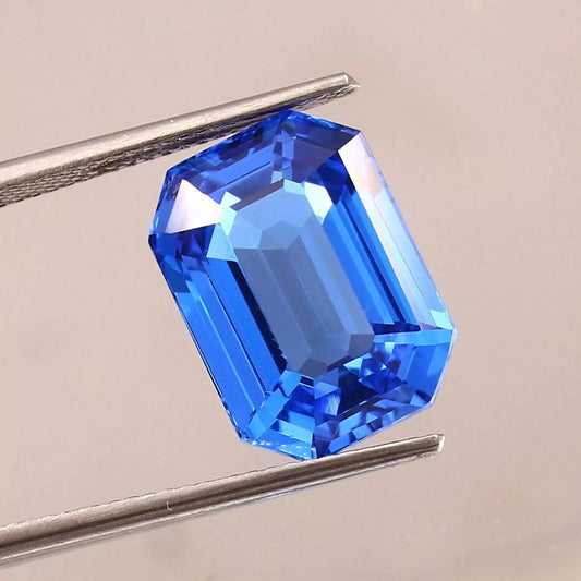 Blue sapphire sri lanka gemstone held by tweezers on a neutral background