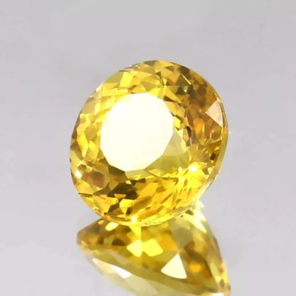 Close-up of a Ceylon Yellow Sapphire gemstone on a light gray background