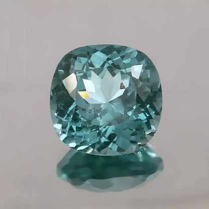 Teal Spinel  gemstone on a gray background