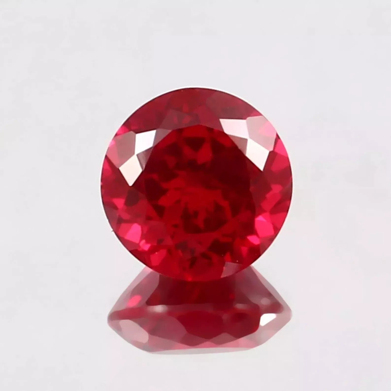 Red Mozambique Ruby gemstone on a light gray background